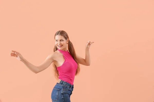 Krásná mladá žena tančí proti barevnému pozadí — Stock fotografie