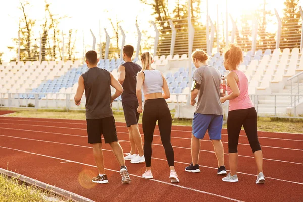 Jóvenes deportivos corriendo en el estadio —  Fotos de Stock