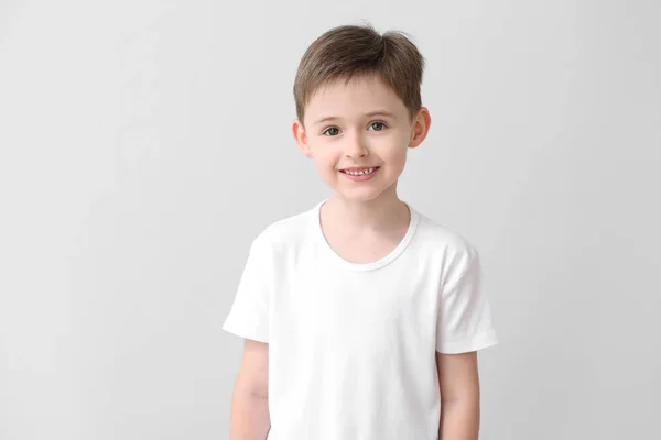 Liten pojke i snygg t-shirt på ljus bakgrund — Stockfoto