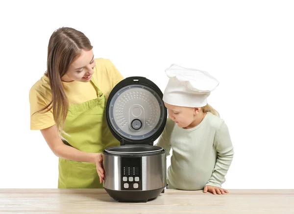 Woman and her little daughter with modern multi cooker on white background — Stock Photo, Image