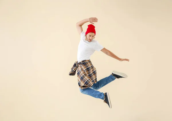 Jumping young man against light background — Stock Photo, Image