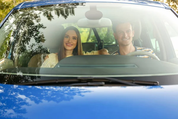Šťastný pár sedí v novém autě, pohled z okna čelního skla — Stock fotografie
