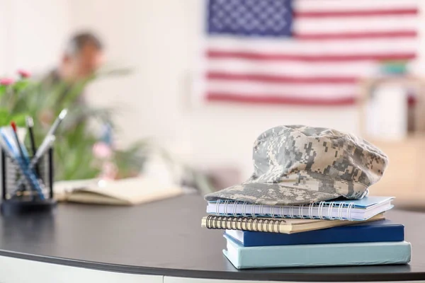 Cuadernos y gorra militar sobre la mesa en el edificio del cuartel general — Foto de Stock