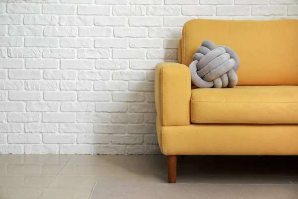 Soft armchair with stylish pillow near white brick wall — Stock Photo, Image