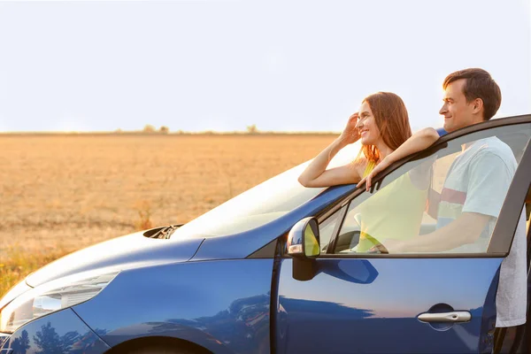 Pareja feliz con su coche nuevo en el campo — Foto de Stock