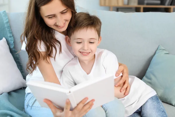 Lille pojken och hans äldre syster läser bok hemma — Stockfoto