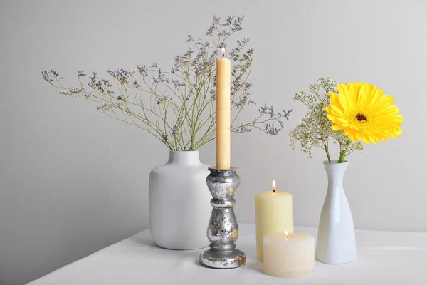 Красиві палаючі свічки з квітами на столі — стокове фото