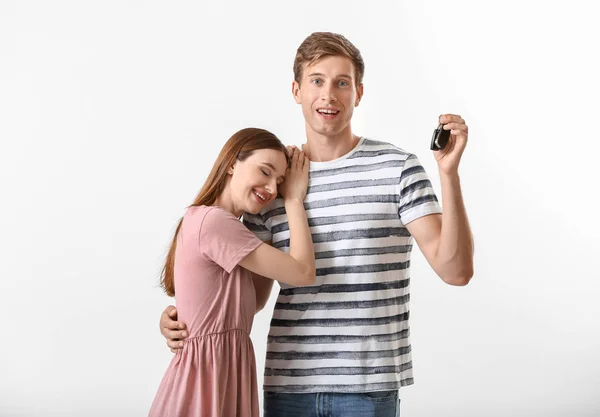 Feliz joven pareja con llave de coche nuevo sobre fondo blanco — Foto de Stock