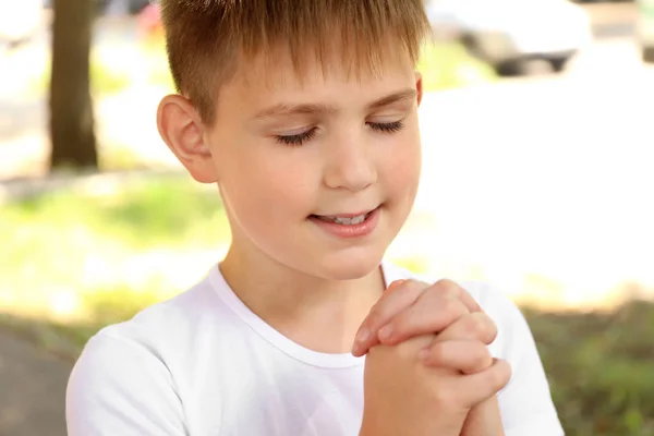 Cute little boy praying outdoors — Stock Photo, Image