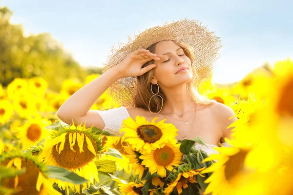Schöne junge Frau im Sonnenblumenfeld an einem Sommertag — Stockfoto