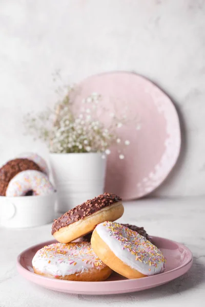 Bord met lekkere donuts op lichte achtergrond — Stockfoto
