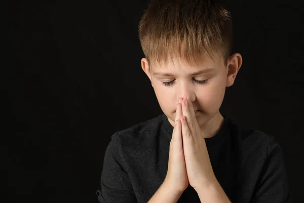 Praying little boy on dark background — Stock Photo, Image