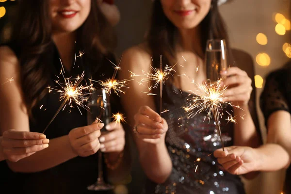 Mujeres felices con bengalas de Navidad y copas de champán en la fiesta —  Fotos de Stock