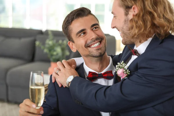 Feliz gay casal com champanhe no seu casamento dia no casa — Fotografia de Stock