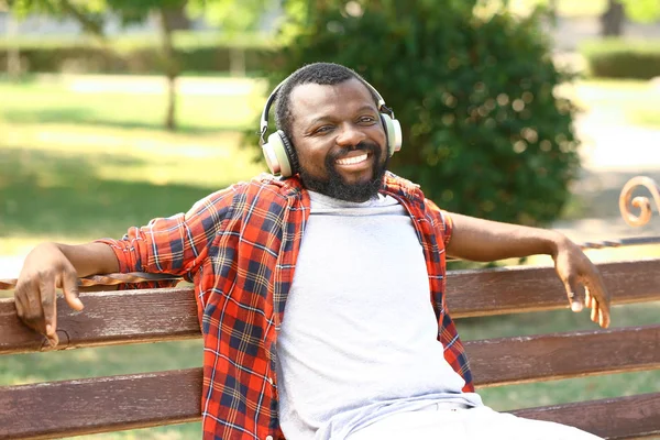 African-American man listening to music in park — Stock Photo, Image