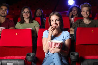 Genç kadın sinema film izlerken patlamış mısır ile