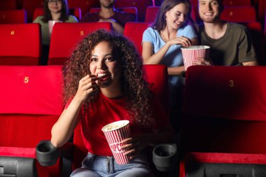 Patlamış mısırlı Afro-Amerikalı kadın sinemada film izliyor