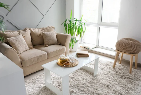 Acogedor sofá con mesa y planta tropical en el elegante interior de la habitación — Foto de Stock