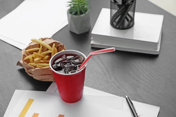 Copa de cola fría con papas fritas en la mesa en la oficina — Foto de Stock