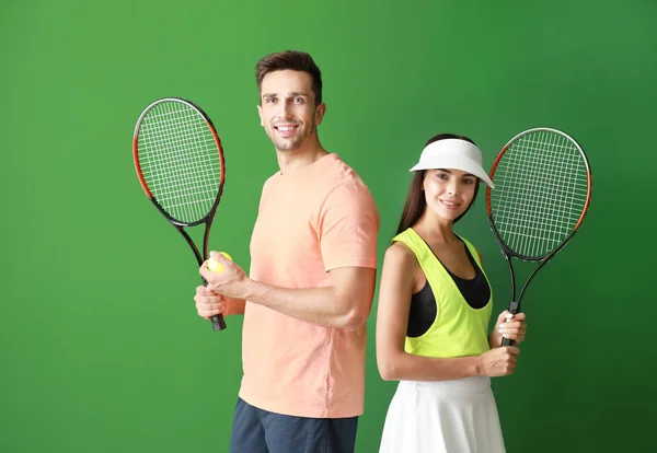 젊은 부부 와 테니스 라켓 에 색상 배경 — 스톡 사진