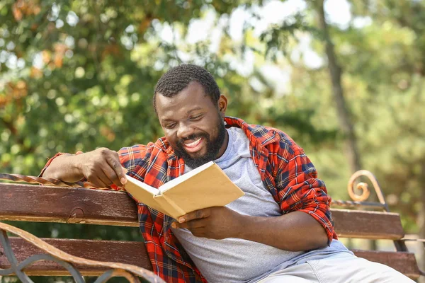 Hombre afroamericano leyendo libro en el parque — Foto de Stock