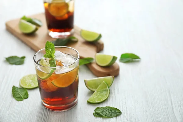 Glasses of cold cola, lime and mint on table — Stock Photo, Image