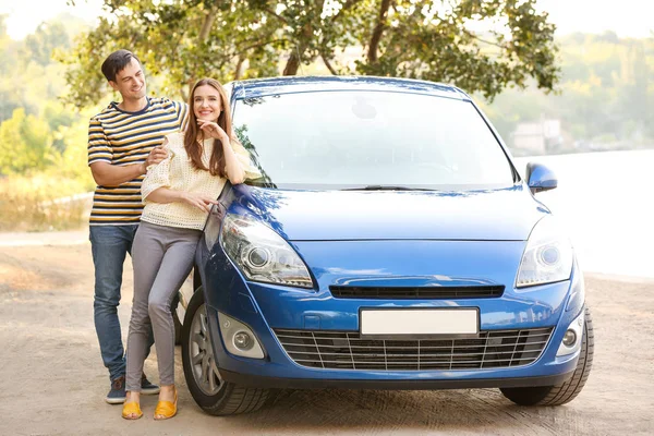 Happy couple near their new car outdoors — Stock Photo, Image