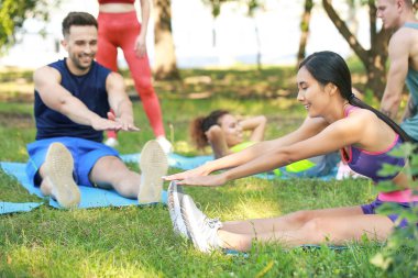 Açık havada birlikte eğitim alan bir grup genç sportif insan