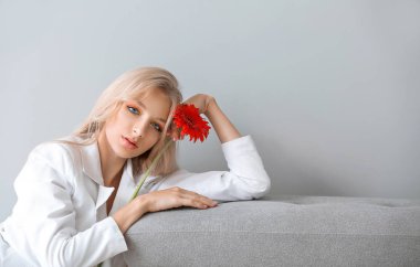 Beyaz arka plan üzerinde gerbera çiçek ile güzel genç kadın