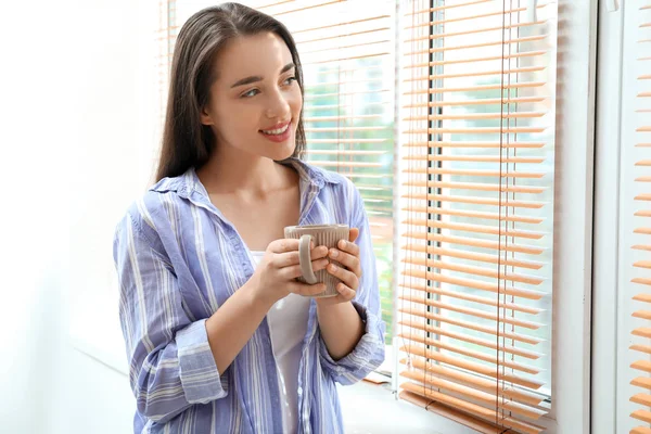 Mañana de hermosa joven bebiendo café cerca de la ventana — Foto de Stock