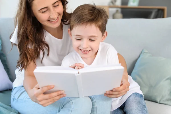 Lille pojken och hans äldre syster läser bok hemma — Stockfoto