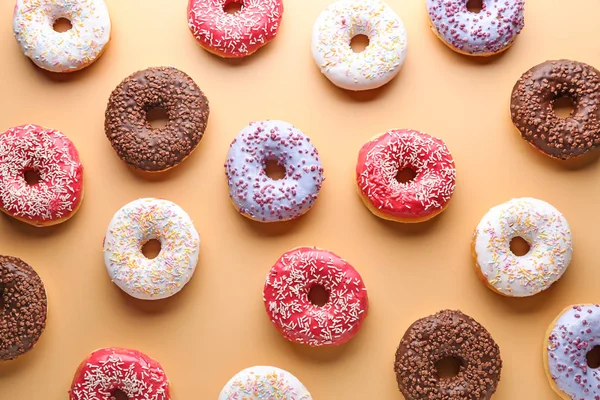 Donuts saborosos diferentes no fundo da cor — Fotografia de Stock