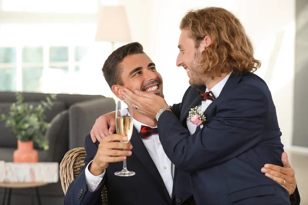 Feliz gay casal com champanhe no seu casamento dia no casa — Fotografia de Stock
