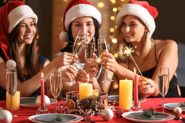 Щасливі жінки з різдвяними блискітками і келихами шампанського на вечірці — стокове фото