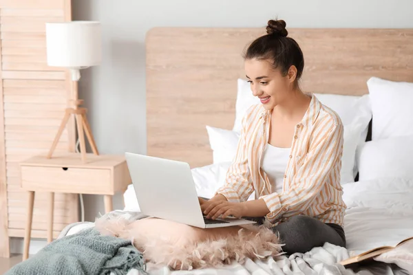Morning of beautiful young woman with laptop in bedroom — Stock Photo, Image
