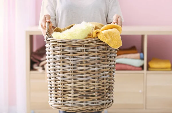 Mulher segurando cesta com lavanderia em casa — Fotografia de Stock