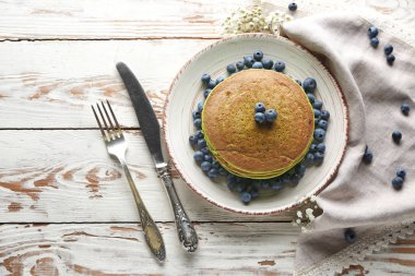 Beyaz masada yeşil krep ve taze çilek ile Tabak