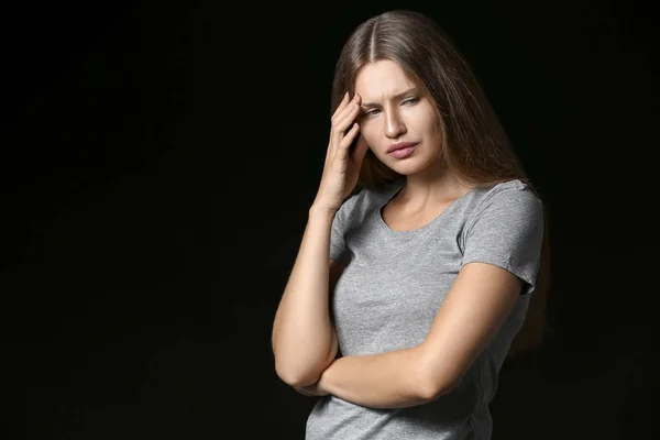 Gestresste junge Frau auf dunklem Hintergrund — Stockfoto