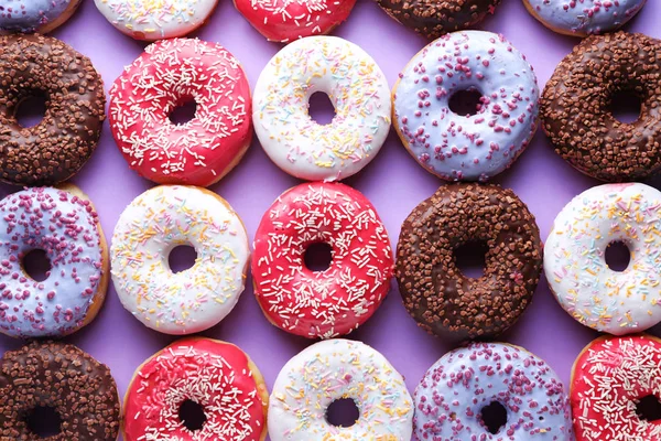 色の背景に異なるおいしいドーナツ — ストック写真