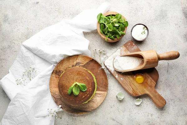 Bord met groene pannenkoeken en ingrediënten op een grijze achtergrond — Stockfoto