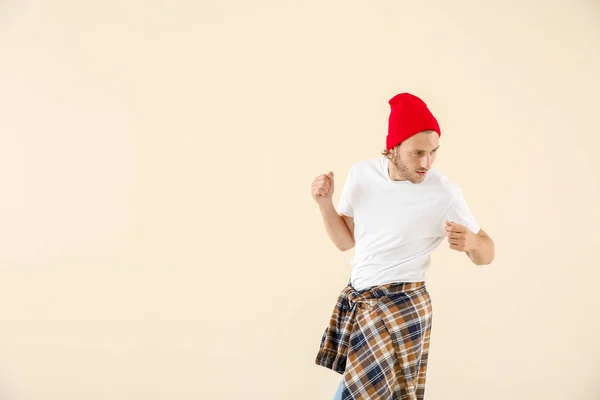 Cool young man dancing against light background — Stock Photo, Image