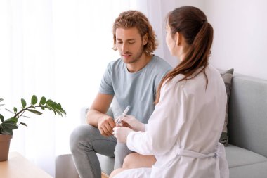 Doktor diyabetik adamın kan örneği klinikte alarak