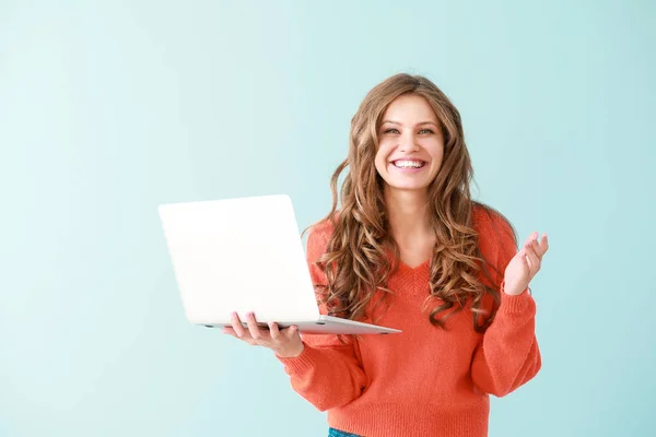 Portret szczęśliwej młodej kobiety z laptopem na kolorowym tle — Zdjęcie stockowe