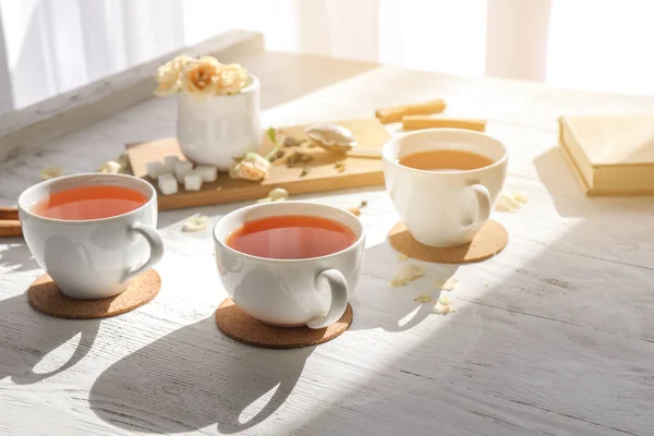Cups of hot tea on white wooden table — Stock Photo, Image