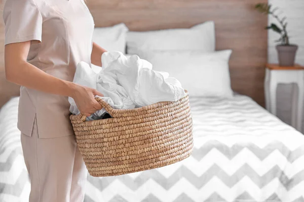 Woman holding basket with laundry in bedroom — Stock Photo, Image
