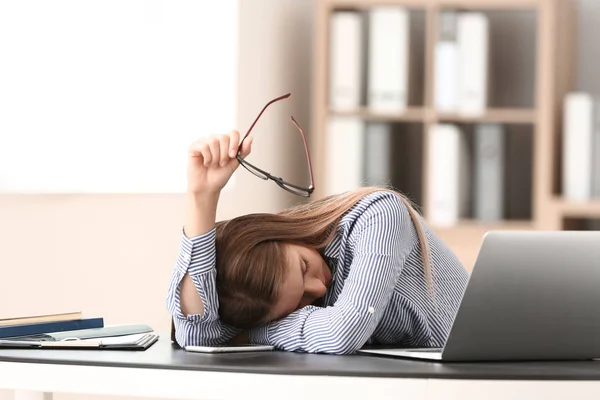 Mujer joven estresada en la mesa en la oficina —  Fotos de Stock