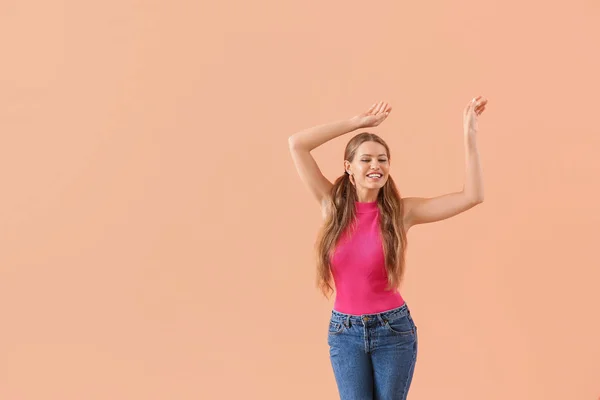 Beautiful young woman dancing against color background — Stock Photo, Image