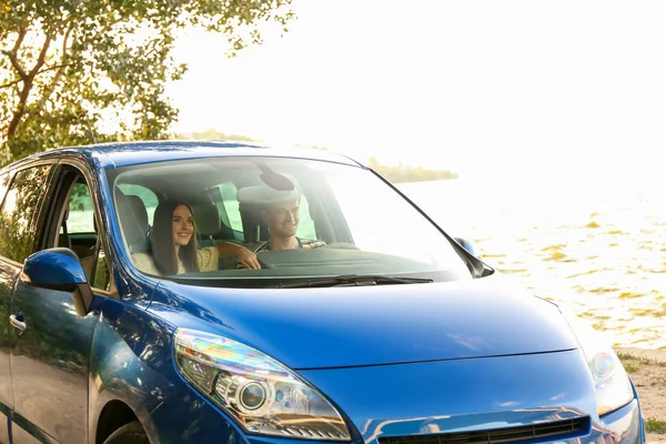Happy couple sitting in their new car, view from windshield window — Stock Photo, Image