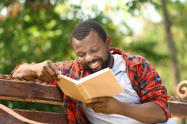 Africano-americano homem leitura livro no parque — Fotografia de Stock