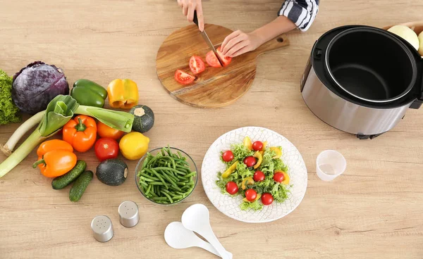 Woman cutting vegetables for stewing in multi cooker — Stock Photo, Image